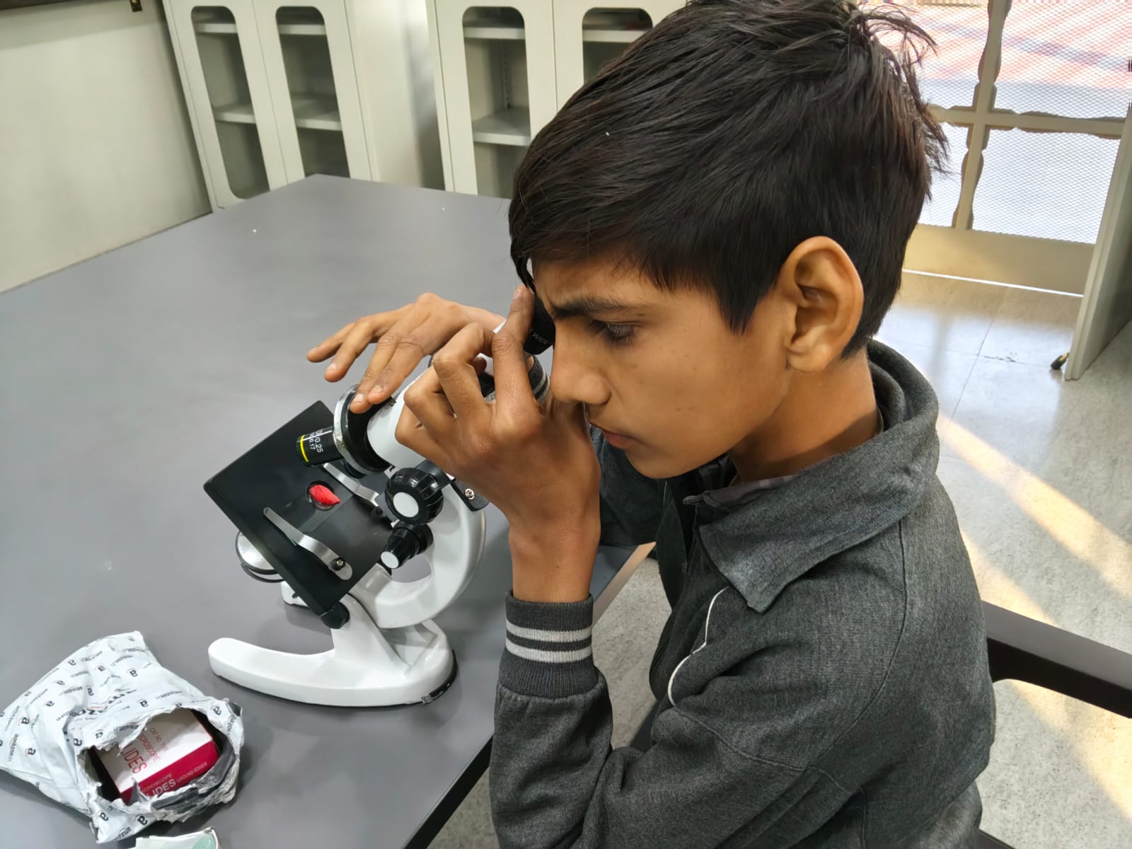 Student exploring science through a microscope